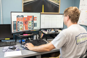 man sitting at computer preparing packaging artwork for co-packing companies